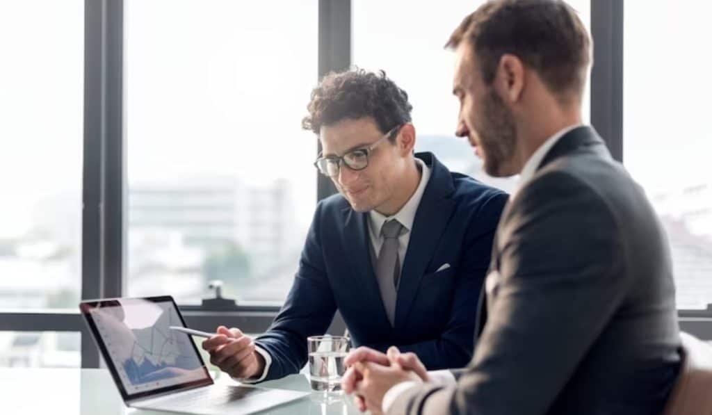 Dos hombres hablan sobre los resultados financieros de una compañía