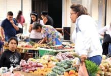 Mujer hace compras de alimentos en una plaza de mercado de Colombia